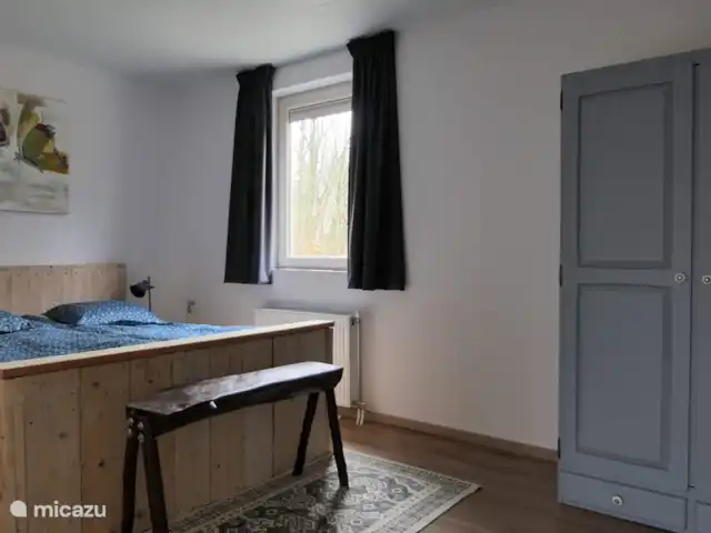 BuitenGewoon huren in Nederland, Drenthe, Westerbork - vakantiehuis Slaapkamer met een stoer steigerhouten bed voor 2 personen met beweegbare bedbodem en 1 persoonsdekbedden. Door het comfortabele bed en de stilte rond de vakantiewoning zult u heerlijk kunnen slapen. Voor het slaapkamerraam zit een vaste hor, u kunt s'nachts gerust met het raam open slapen.