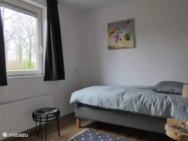 BuitenGewoon huren in Nederland, Drenthe, Westerbork - vakantiehuis Ruime 1 persoons-slaapkamer met boxspring-bed en ruime hang/legkast. Aan de kast zijn haakjes bevestigd waar u uw badjas e.d. op kunt hangen Op de slaapkamervloeren ligt laminaat. Op deze slaapkamer is ruimte voor een camping bedje. Voor het slaapkamerraam zit een vaste hor.