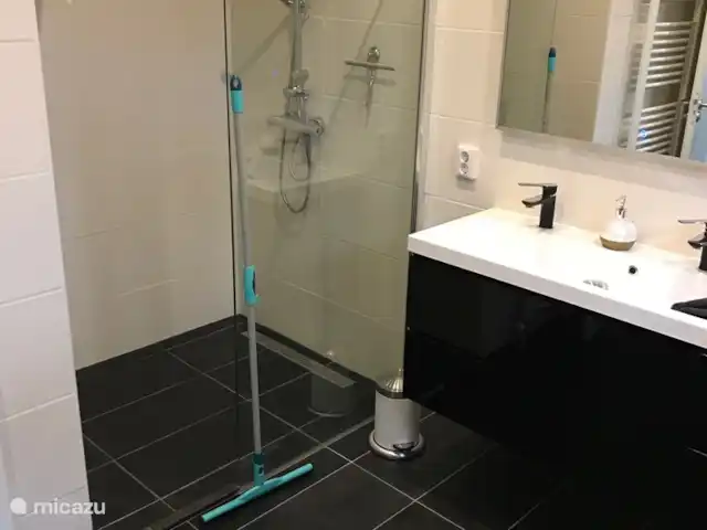 BuitenGewoon huren in Nederland, Drenthe, Westerbork - vakantiehuis De inloopdouche heeft een glazen douchewand. Waar de vloerwisser staat begint de opening. De opening is 51 cm breed.