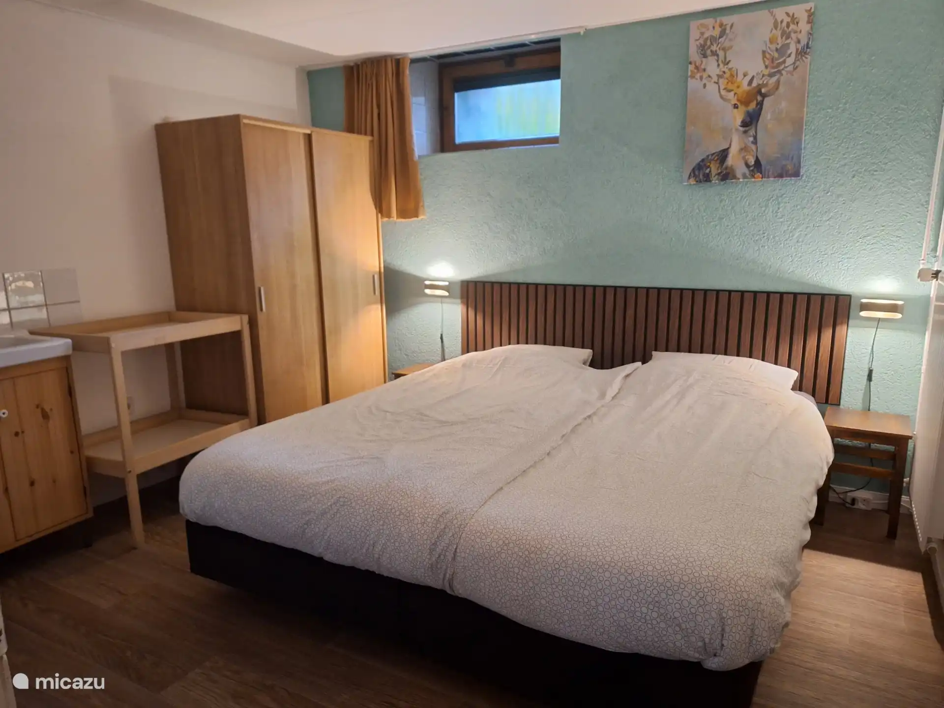 dormitorio con somieres y lavabo, armario y cómoda