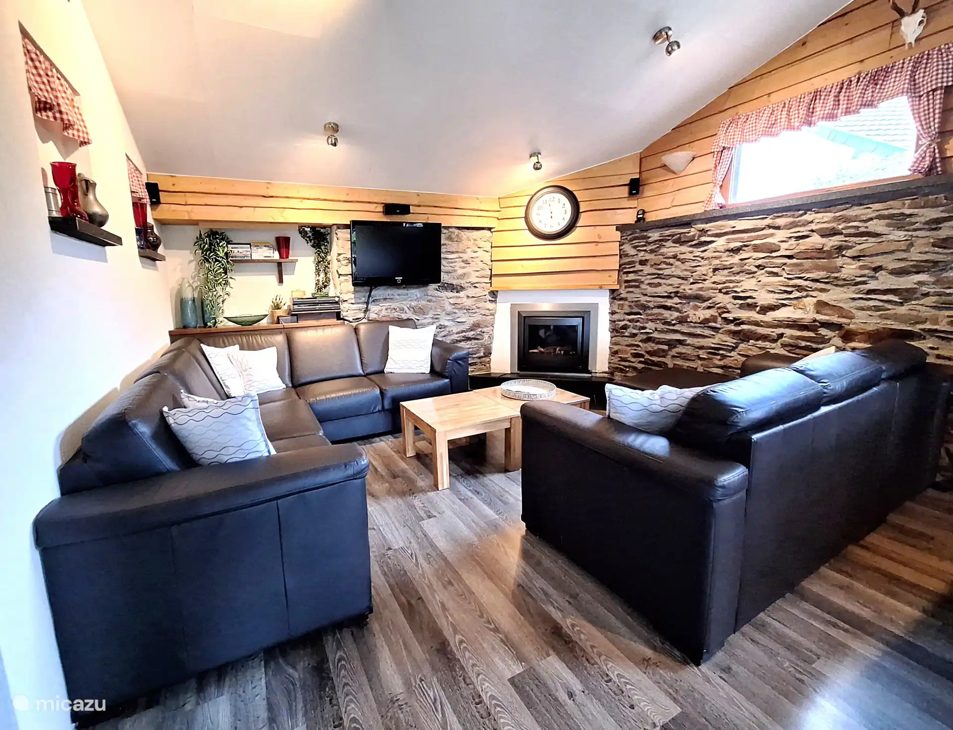Wohnzimmer mit Smart-TV, gemütlichem Kamin und gemütlicher Sitzecke