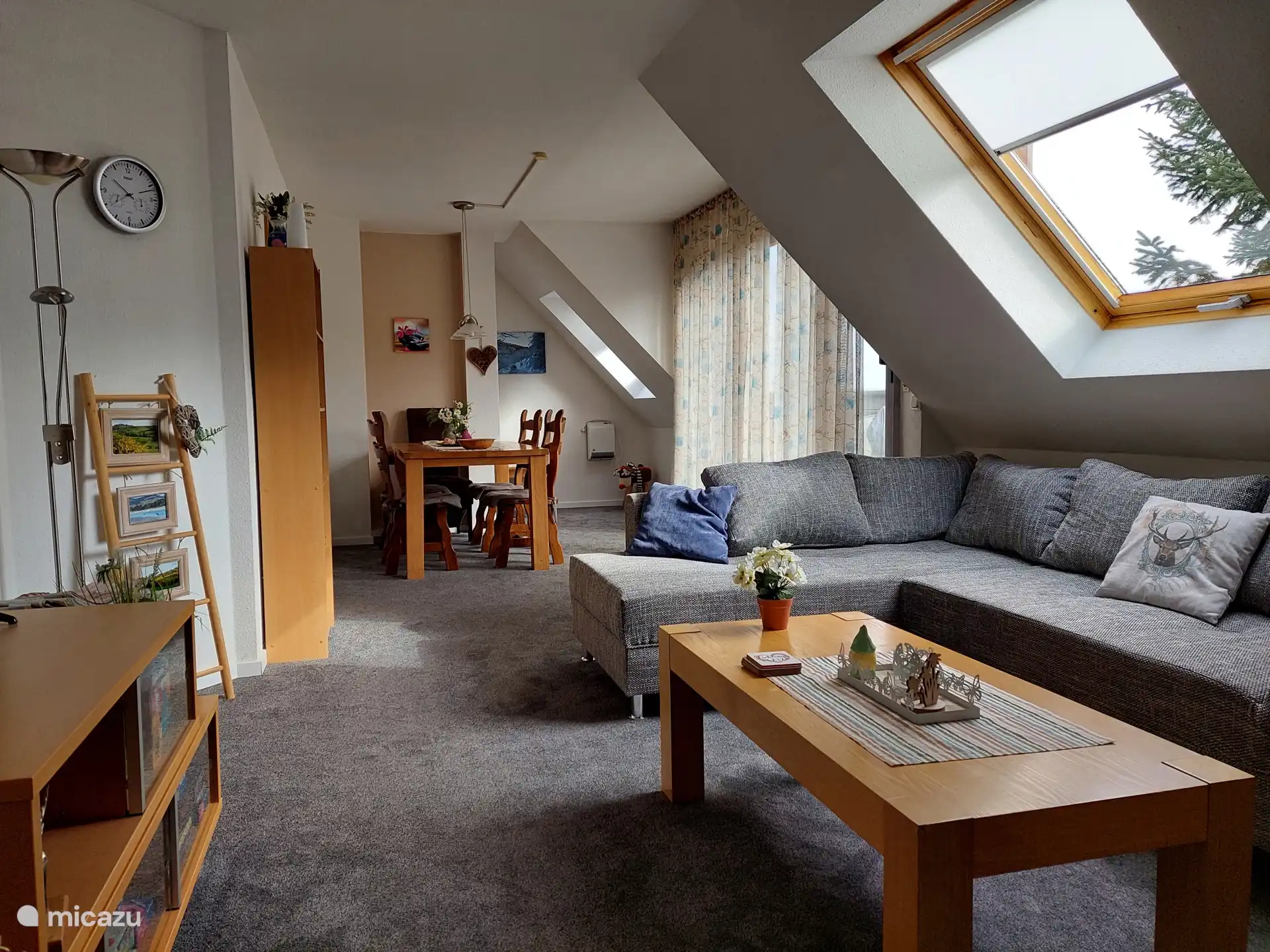 Gezellige woonkamer met eethoek, loungebank en toegang tot het balkon