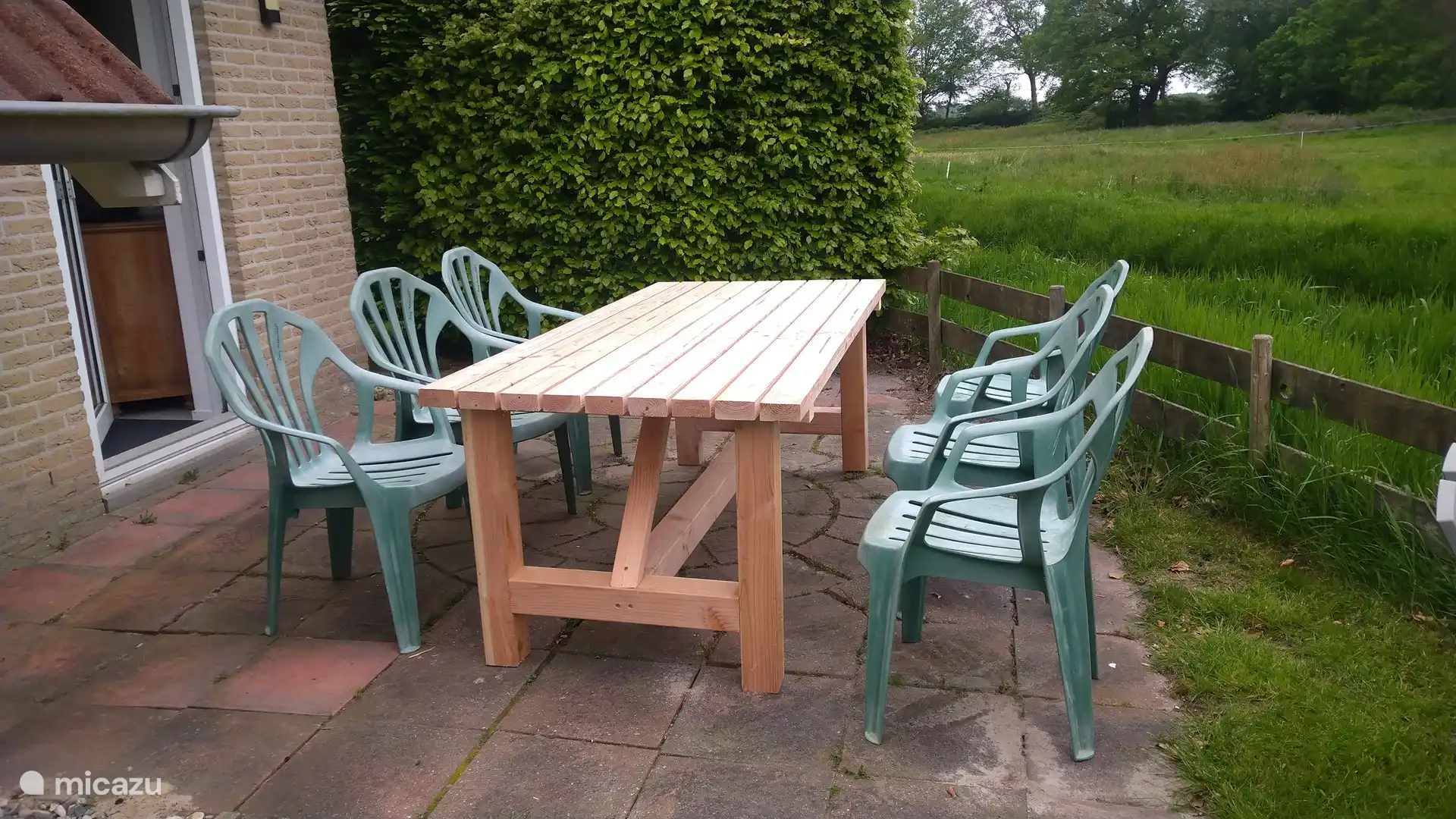 Una amplia mesa de jardín ofrece la oportunidad de disfrutar del desayuno, el almuerzo o la cena al aire libre con una hermosa vista.