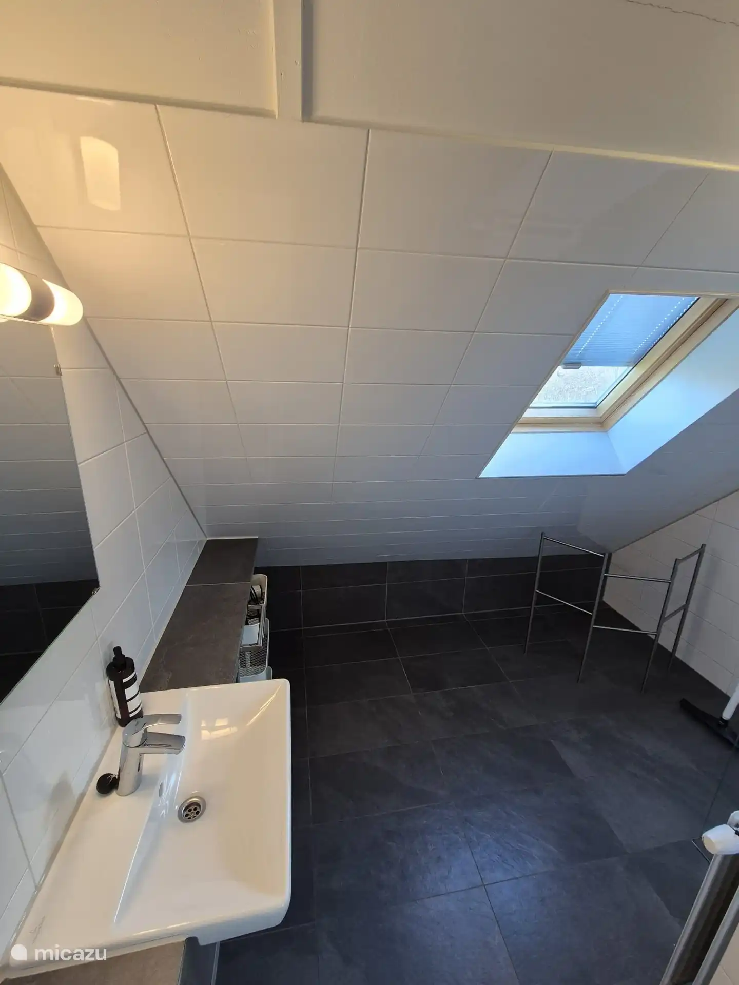 Badezimmer im ersten Stock mit Dusche und Waschbecken. Die Toilette ist separat.