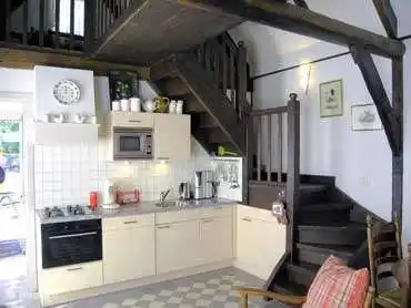 keuken met gasfornuis, oven, afwasmachine, magnetron en koel/vries combinatie