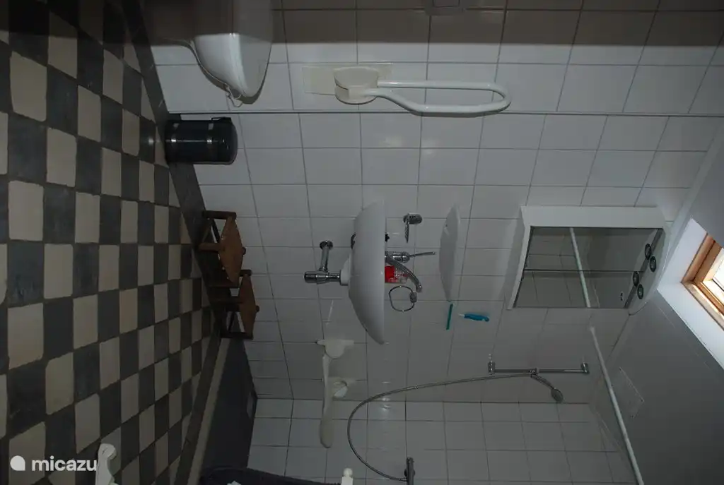 Ruime badkamer, rolstoel toegankelijk, met inloop douche met douche stoel, wastafel en tweede toilet voorzien van beugels.