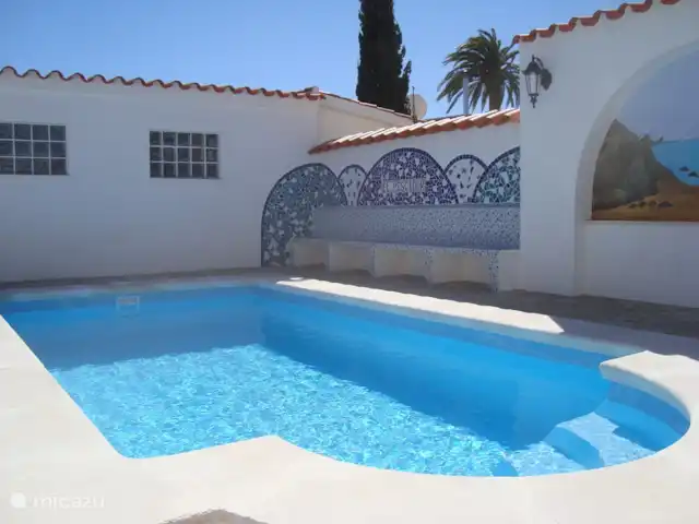 Casa Pescador 'Triadors' Vinaròs en España, Costa del Azahar, Vinaroz - casa vacacional Piscina bellamente ajardinada y bonitas paredes acabadas con un banco.