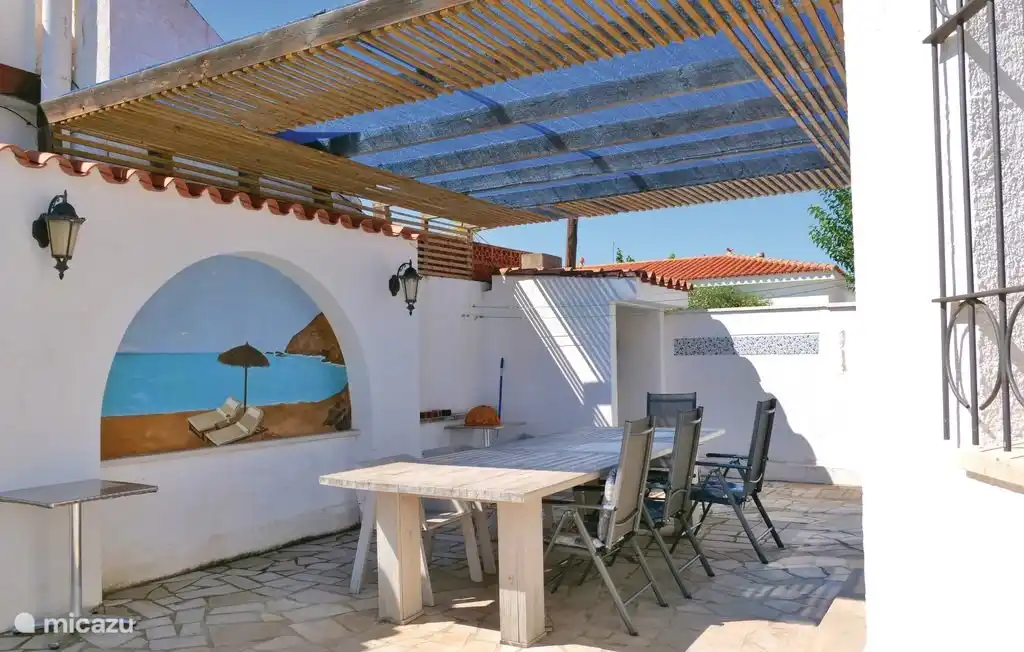 Schöne überdachte Terrasse mit großem Tisch und Grill