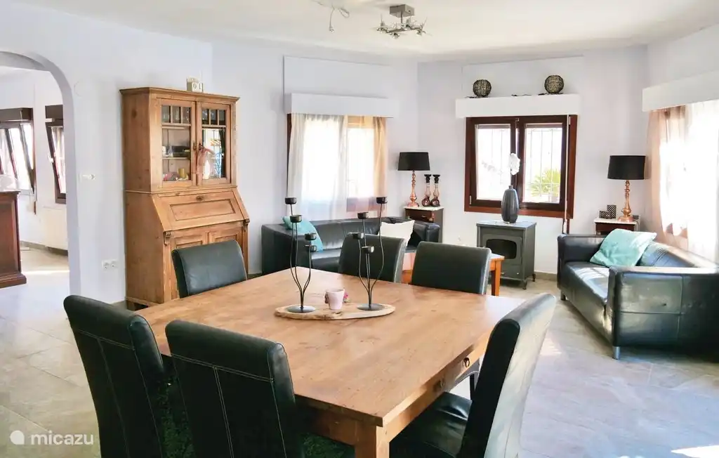 Geräumiges Wohnzimmer mit offener Küche mit Klimaanlage und gemütlichem Holzofen.