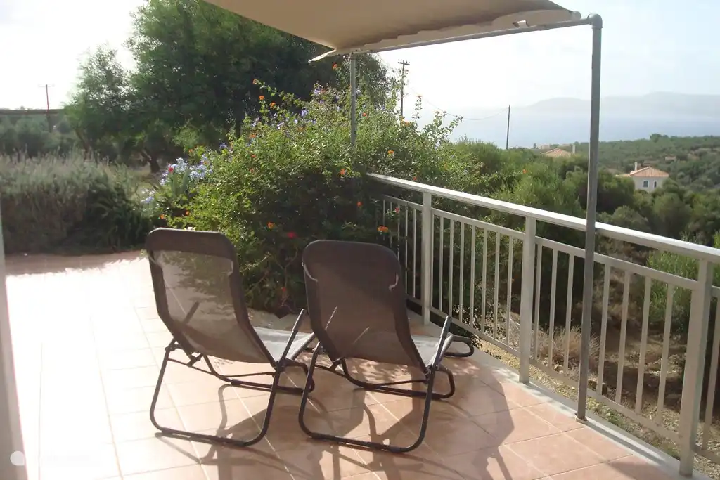 Liegestühle mit Blick auf die Insel Schiza vor der Küste