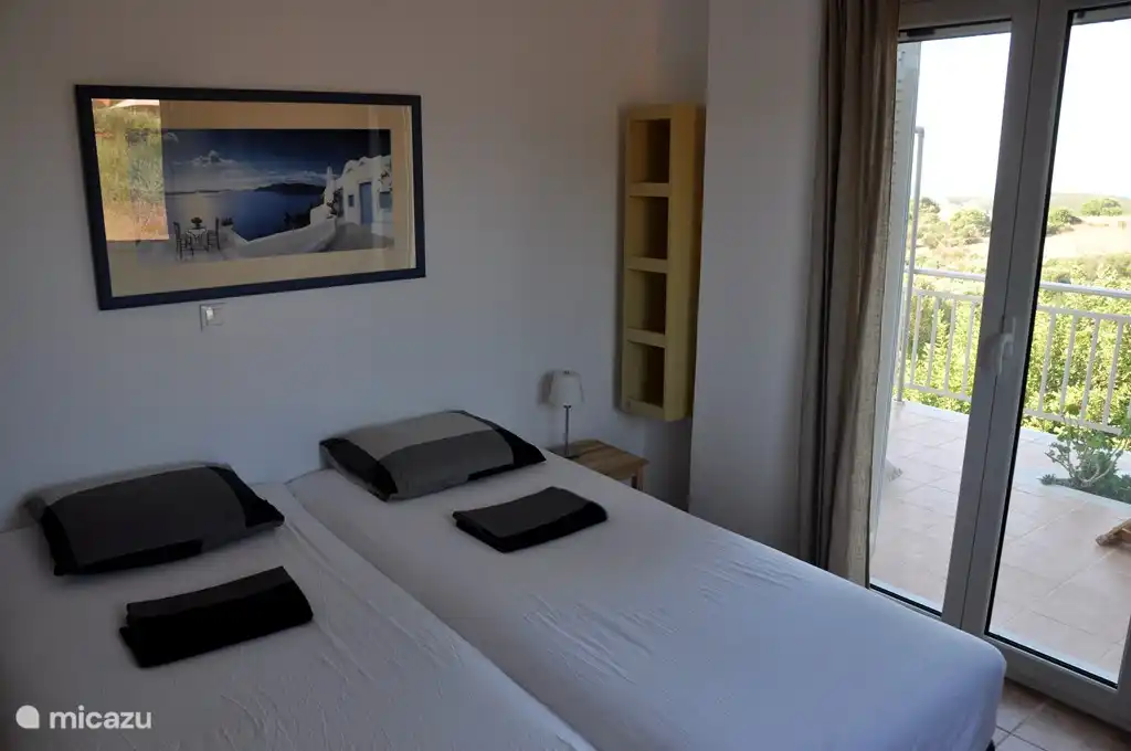 Schlafzimmer im Erdgeschoss mit 2 Betten und offenen Türen zur Terrasse