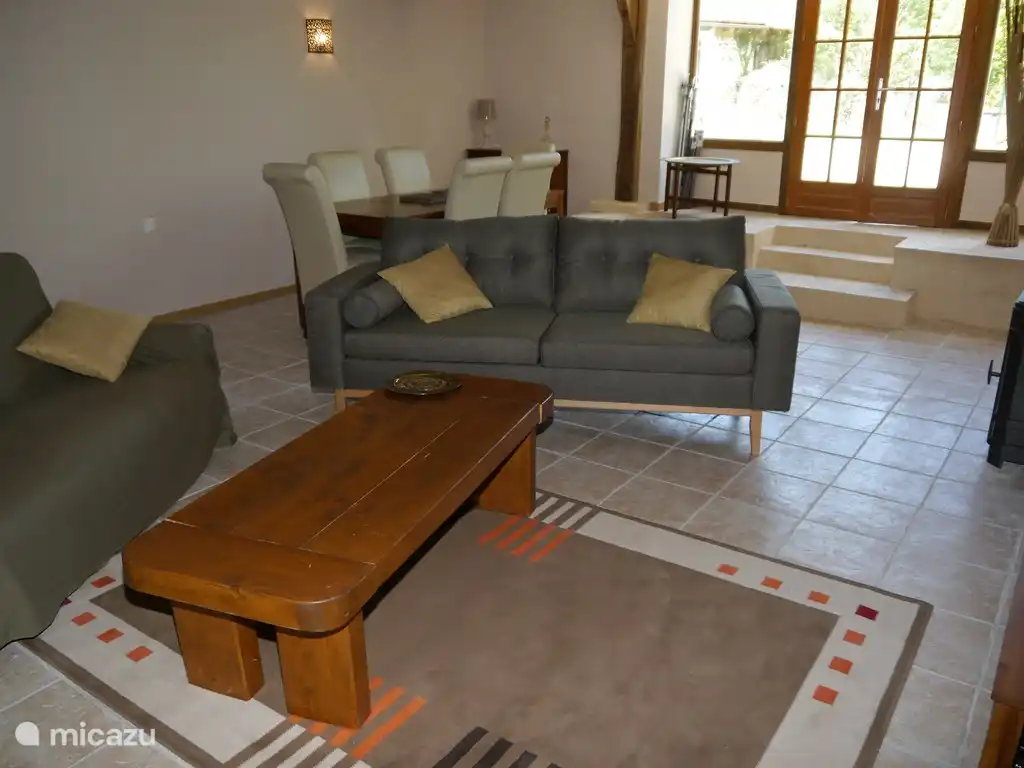 Una sala de estar con 2 cómodos sofás y una mesa de comedor con capacidad para 6 personas.