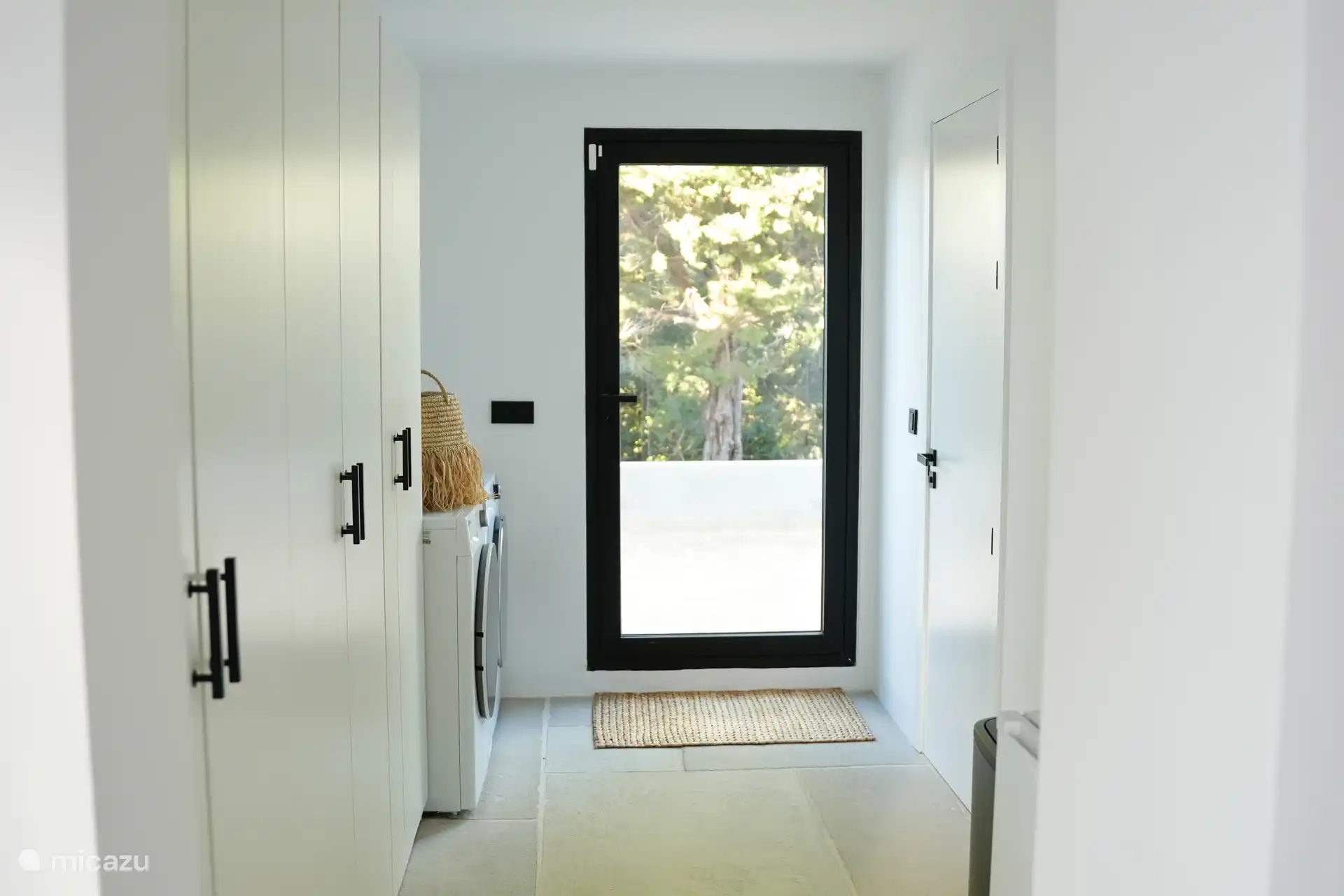 Sala de servicio con lavadora, secadora, congelador, pared grande de armario y baño de invitados 