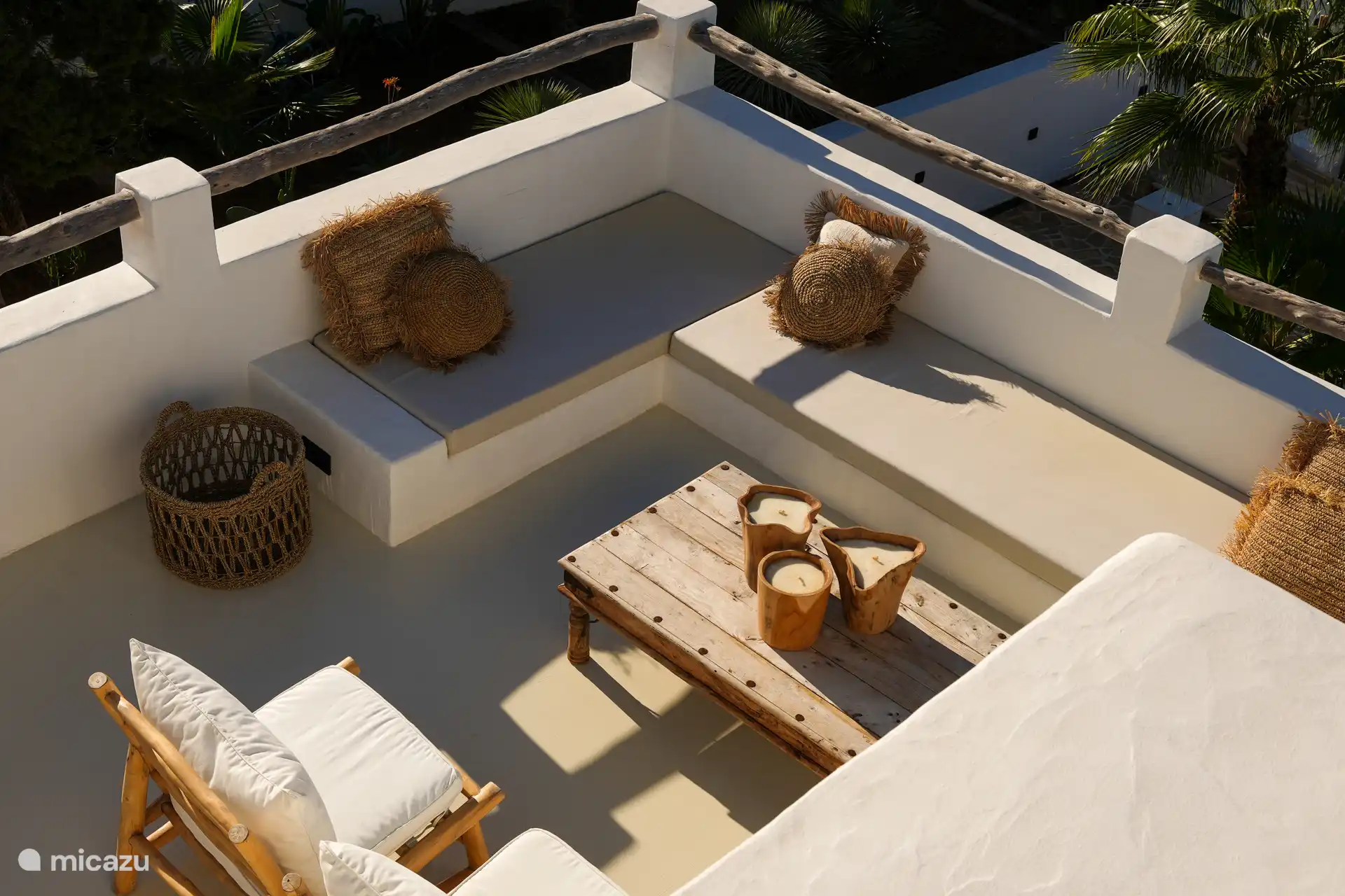 Terraza en la azotea con un gran sofá lounge, butacas de bambú y una vista fantástica al mar