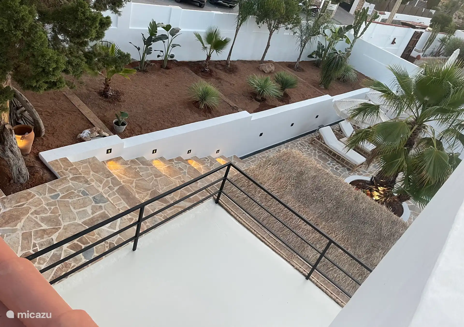 Tropischer Garten mit Beleuchtung und Terrasse mit Sonnenliegen 