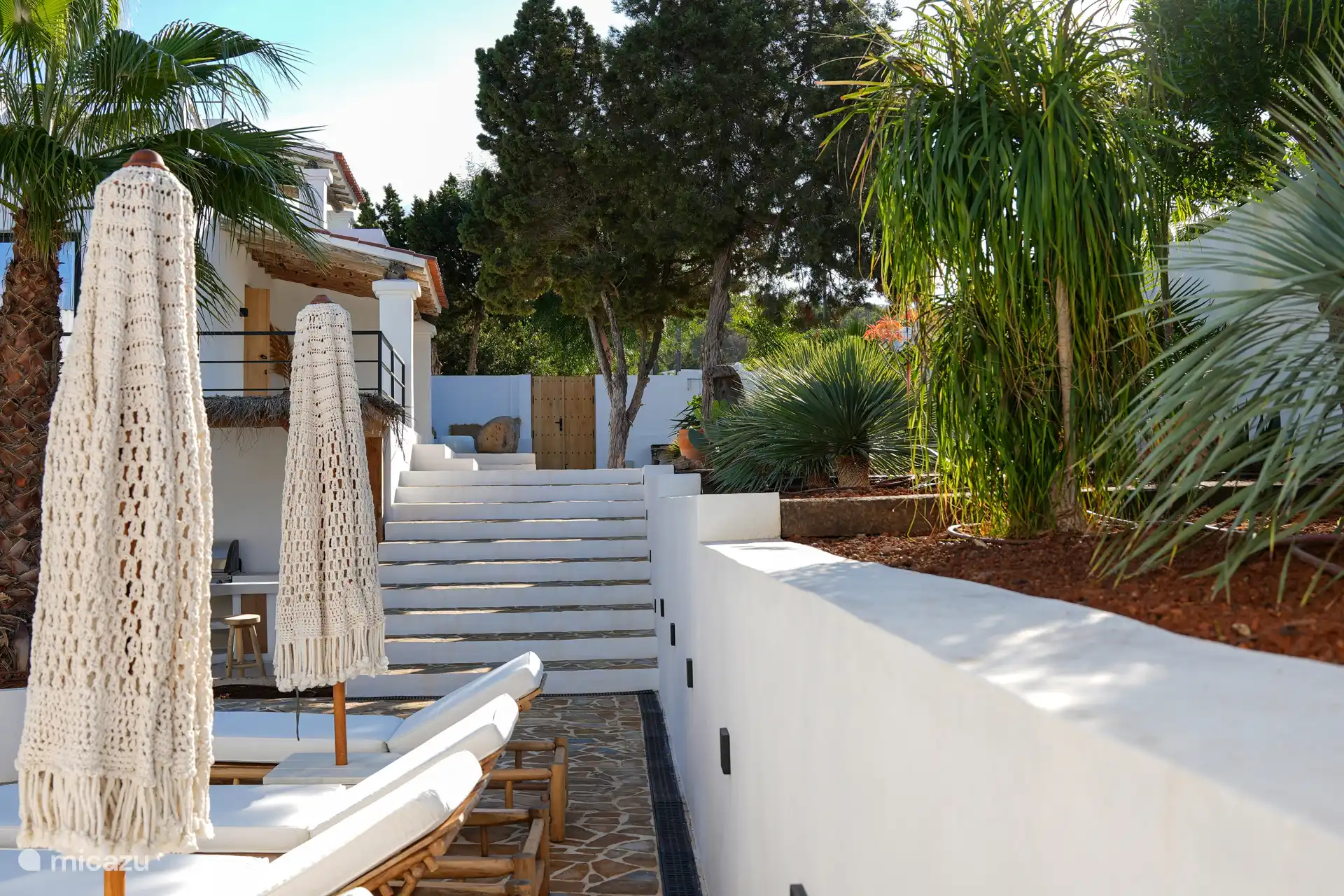 Jardín tropical con varias terrazas y zonas de descanso