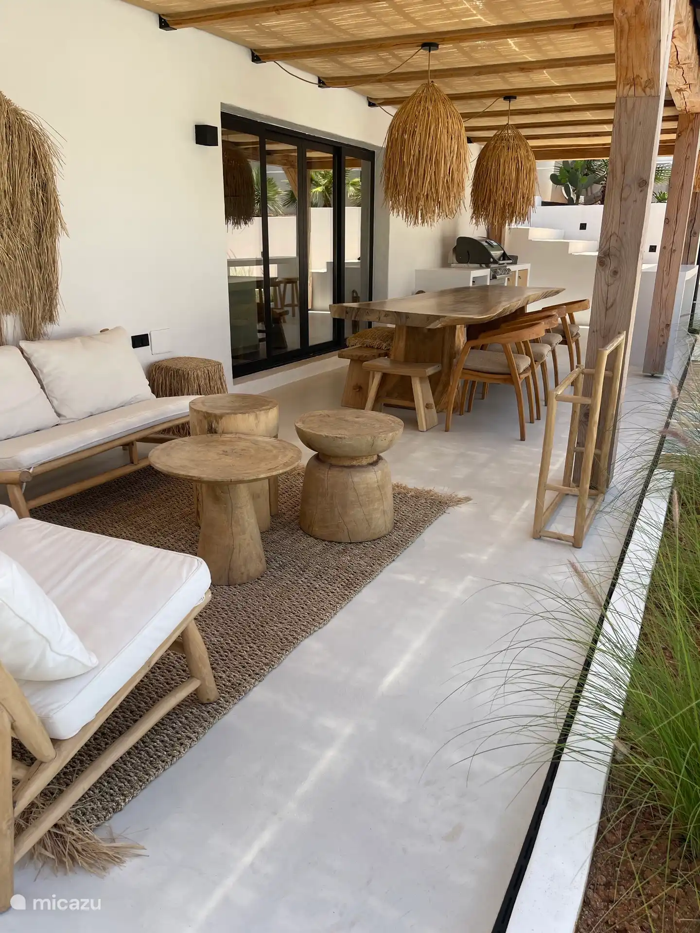Ruime veranda met loungeset, eettafel voor 10 personen, bar met 4 barkrukken en luxe buitenkeuken met barbecue 