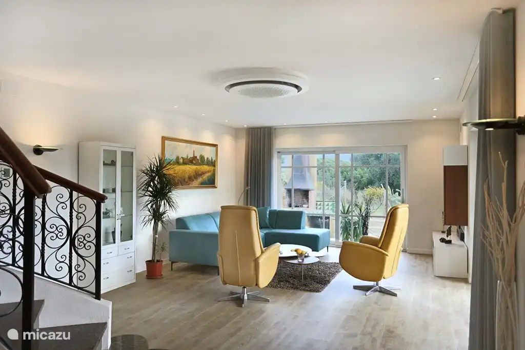 The salon with round air conditioning. On the left the beautiful staircase to the first floor.