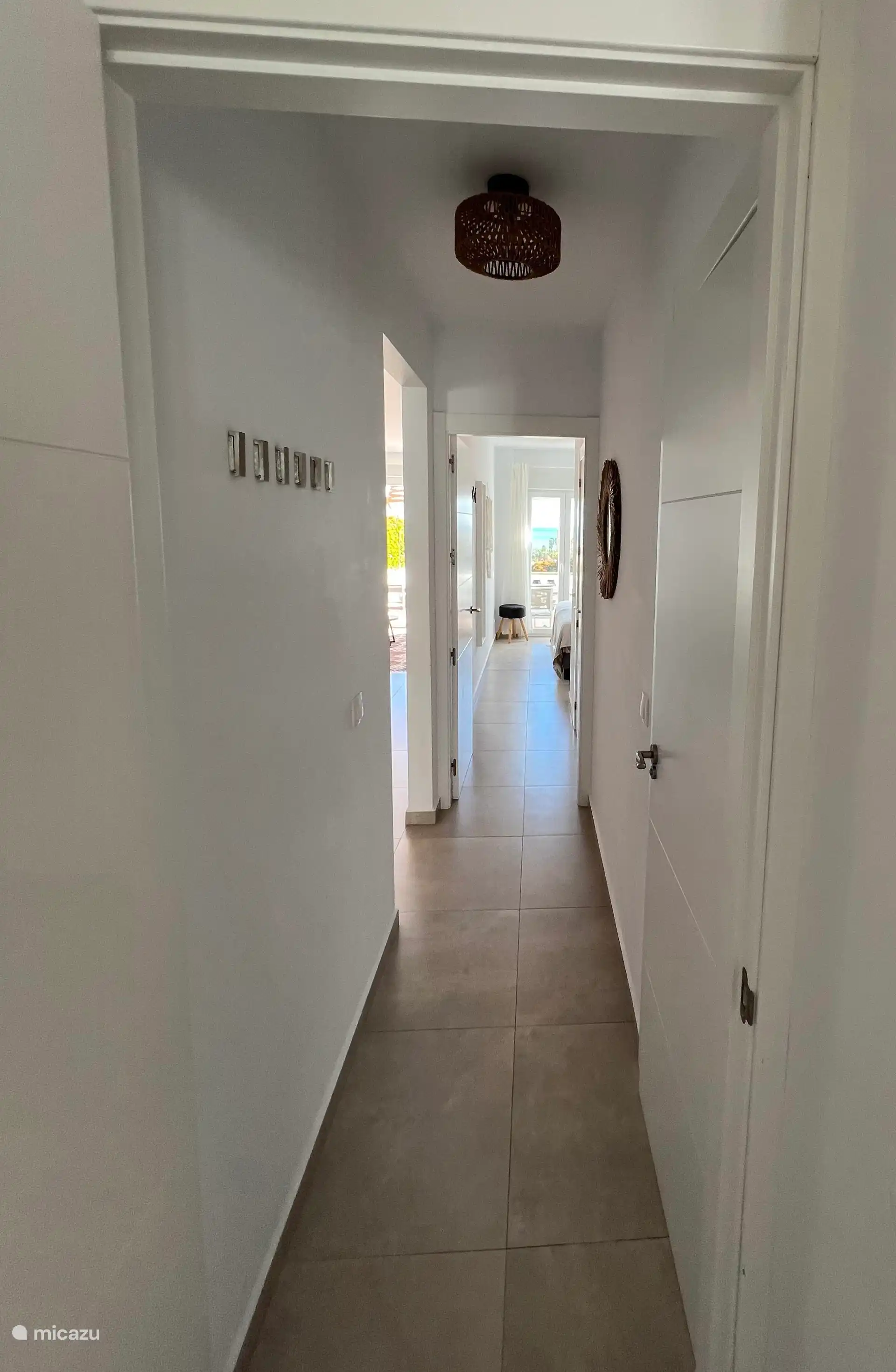 Vue du couloir vers la chambre et les salles de bain.