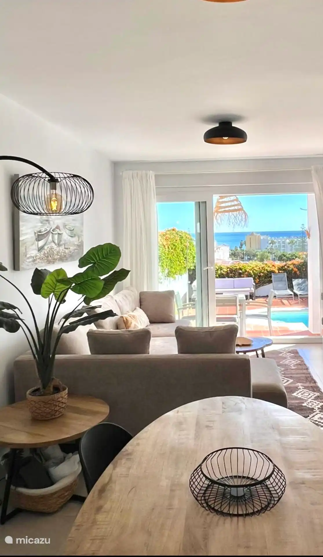 Salon avec vue sur la mer et piscine.