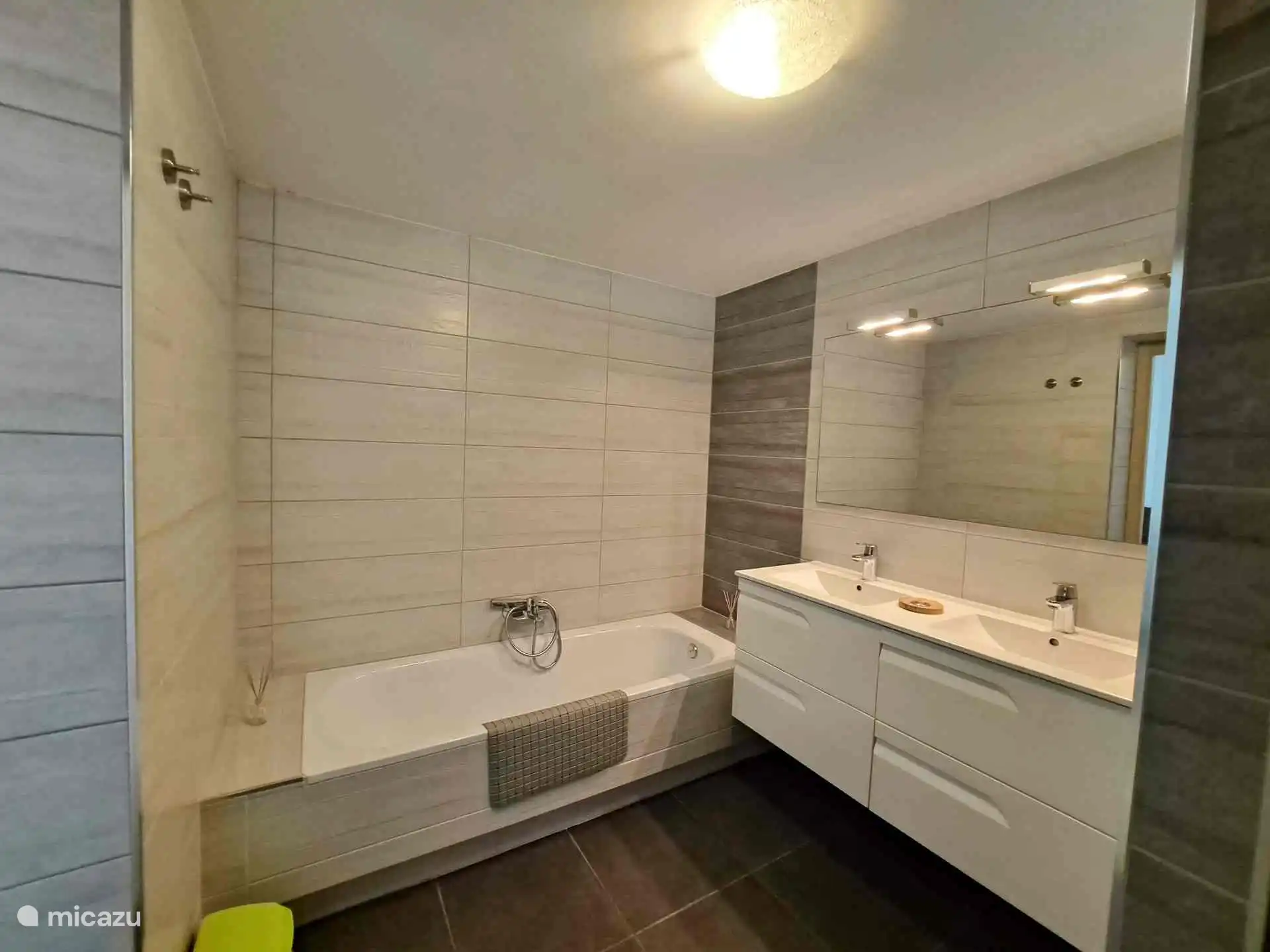 Prive badkamer bij ouder slaapkamer, voorzien van ligbad, inloopdouche, dubbele wastafel en toilet.