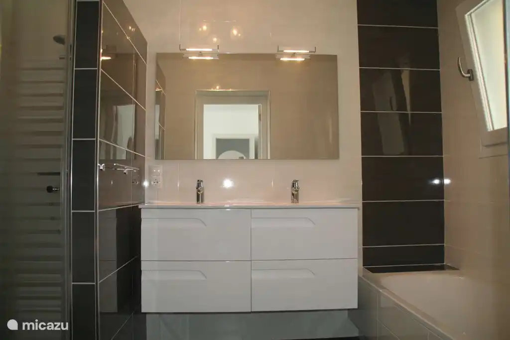 Das eigene Badezimmer der Suite verfügt über eine Dusche, eine Badewanne, ein Doppelwaschbecken und natürlich ein WC.