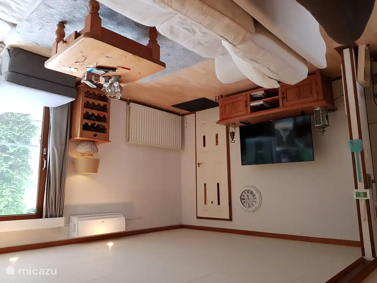 Salon avec grande Smart TV et climatisation.