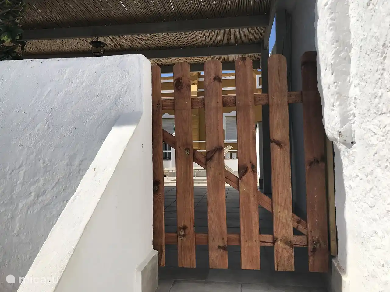 Bescherm poort bovenaan dakterras naar patio (Spaanse benedentuin)