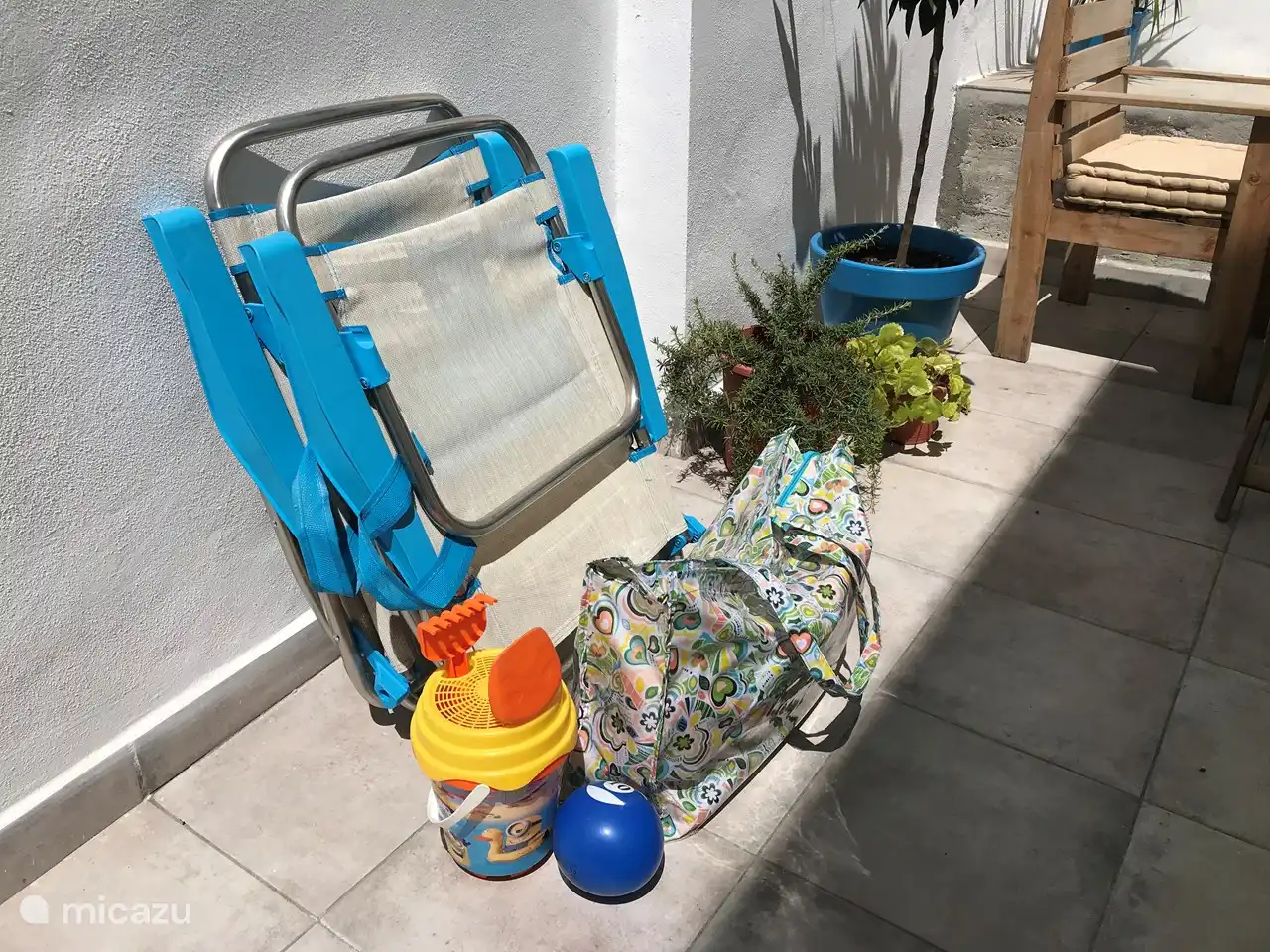 Twee strandstoeltjes, een strandtas en emmer met schepjes beschikbaar.
