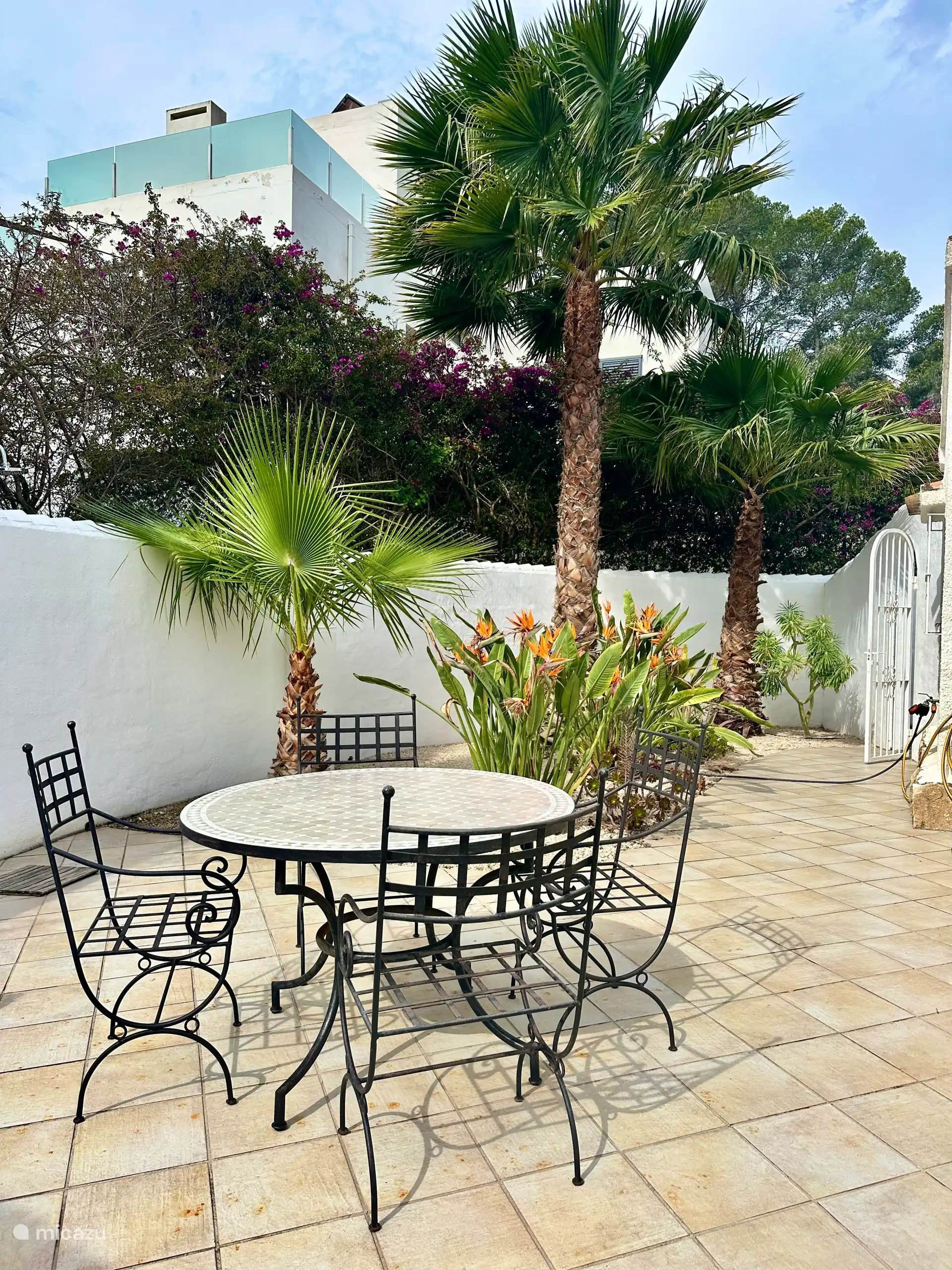 Terras met tafel nabij de buitenkeuken. 