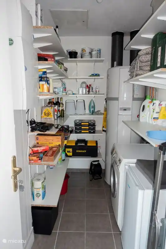 Voorraadkamer met wasmachine, extra koelkast en veel spelletjes.
