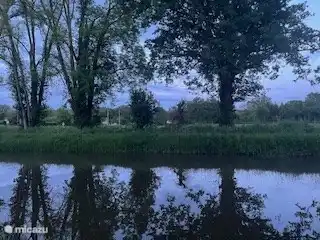 Het Canal de Berry dat achter het huis loopt bij avondschemering. 