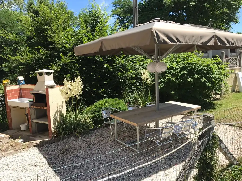Buiten barbecuen en schaduwrijk eten aan een lange tafel: twee ingrediënten voor een zonnig humeur.