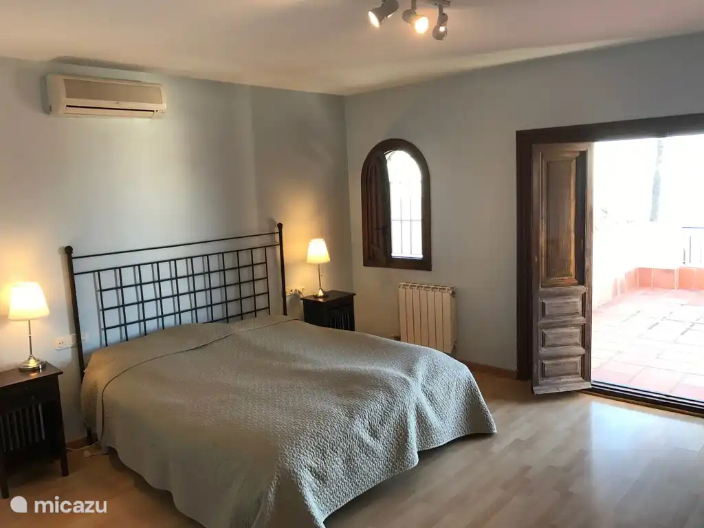 Das Hauptschlafzimmer mit Klimaanlage, eigenem Bad und großer privater Terrasse