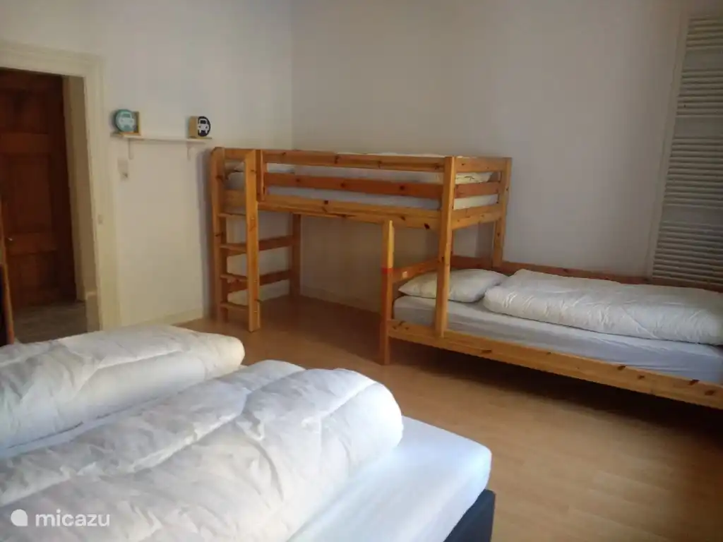 Geräumiges Schlafzimmer mit 2 Einzelbetten und einem Etagenbett.