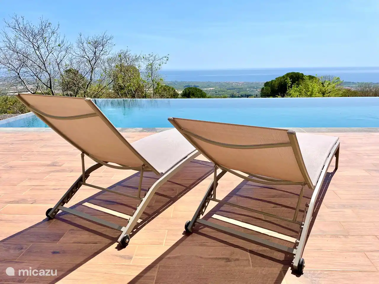 chaises longues au bord de la piscine avec vue sur la mer