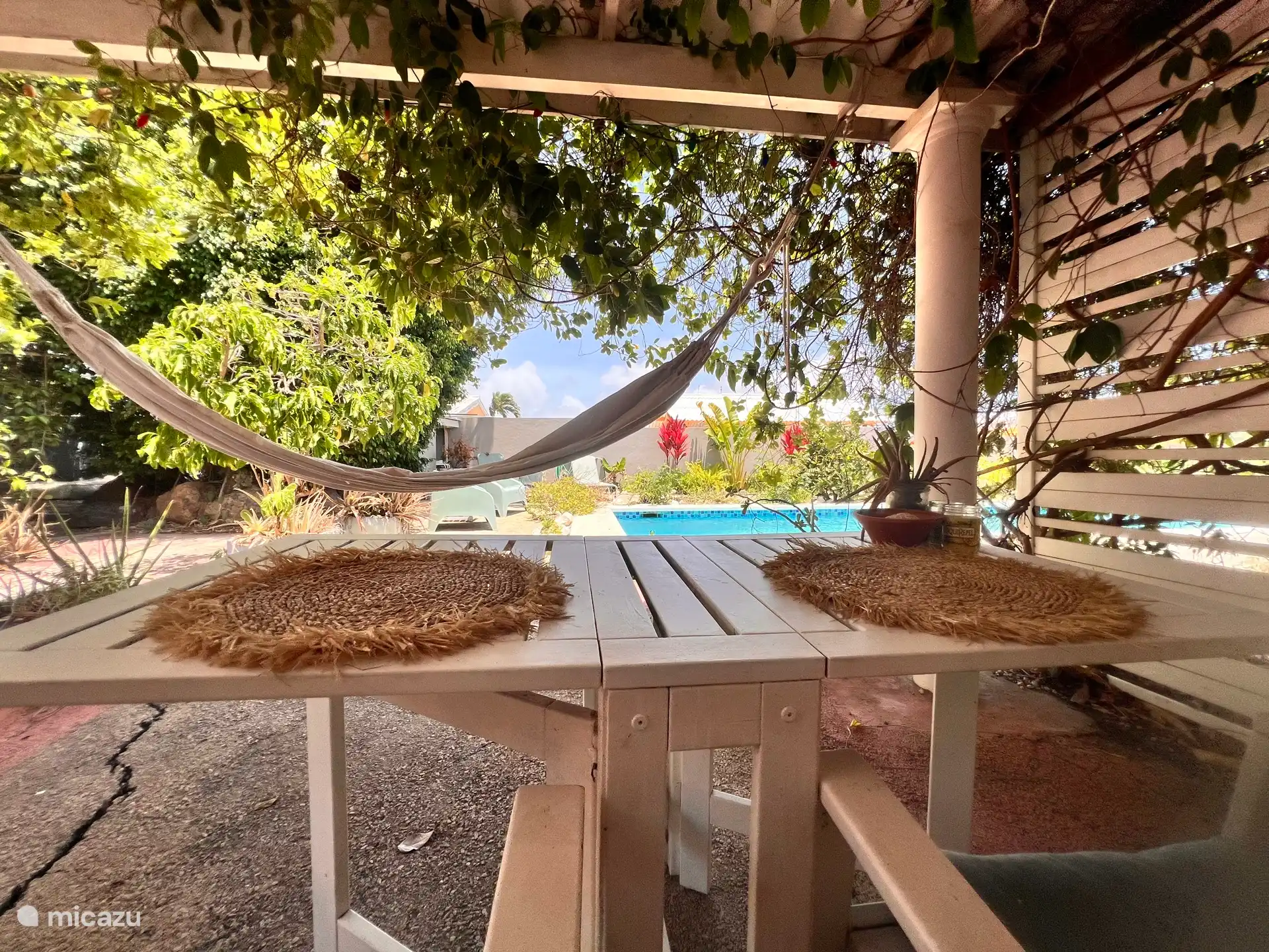 Buiten dient het schaduwrijke, overdekte terras als je eigen privéwoonkamer. Geniet van je ontbijt of diner aan de eettafel, ontspan met een goed boek of kom heerlijk tot rust in de hangmat na een dag