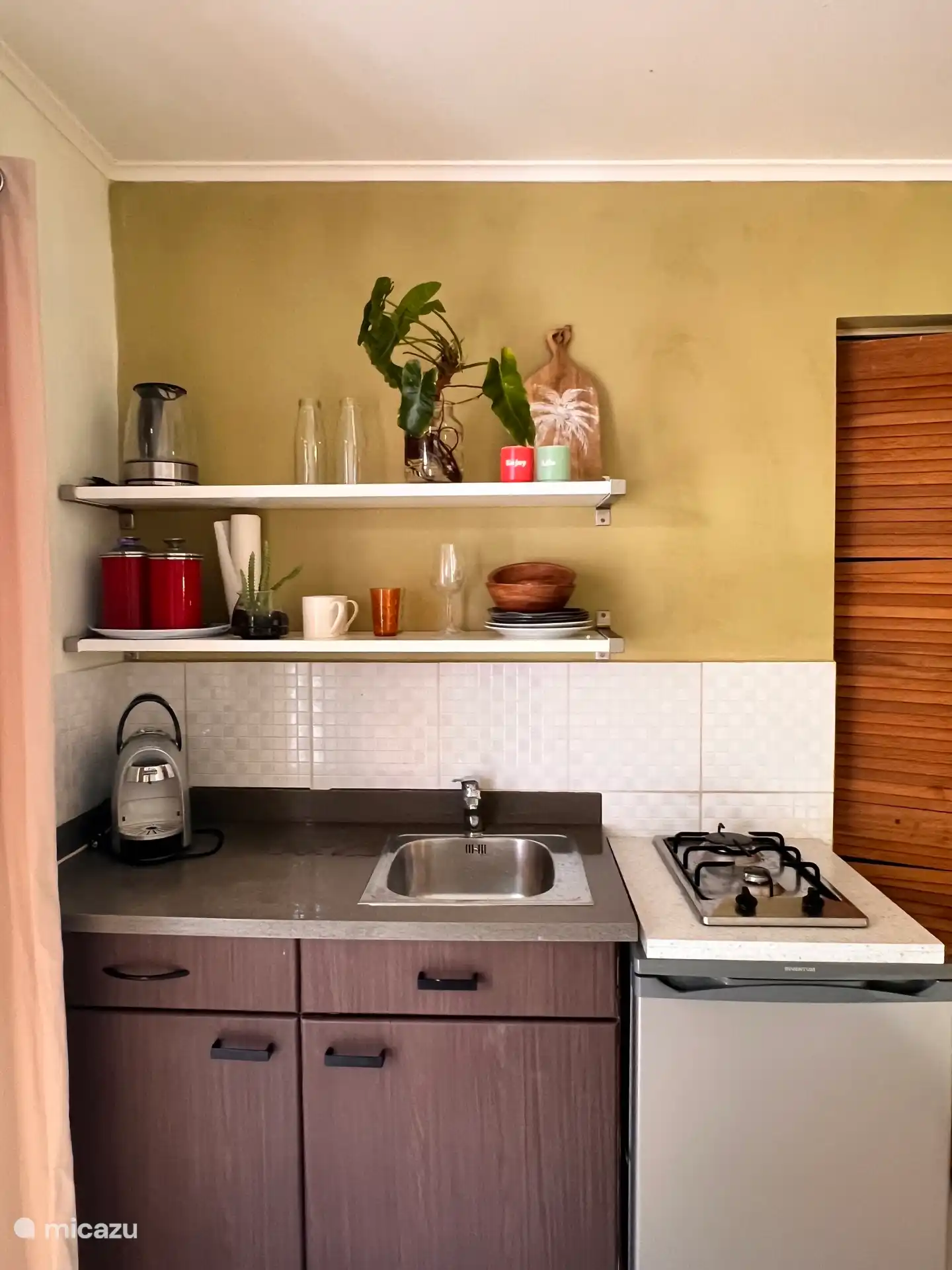 Praktische kitchenette met kookplaat, koelkast, waterkoker en koffiezetapparaat – ideaal voor het bereiden van een ontbijt of eenvoudige maaltijd.

