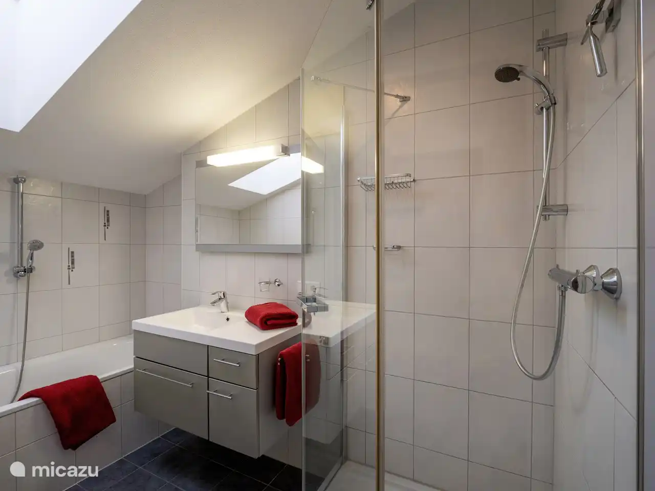Cuarto de baño moderno con lavabo, bañera, ducha separada y calefacción por suelo radiante.