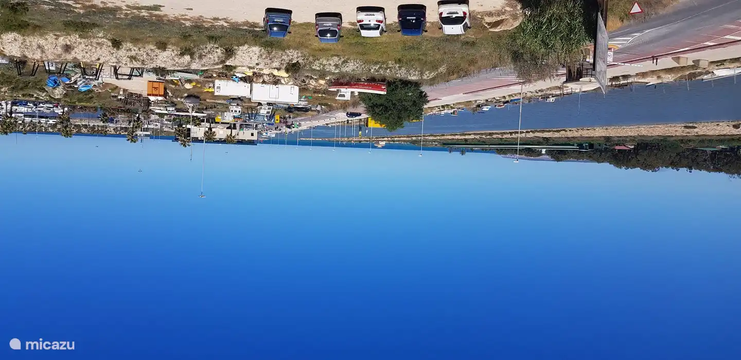 vista desde el balcón sobre el canal y el mar mediterráneo y barrera para ingresar al área del puerto. Tarifa de estacionamiento 1 euro por día. Aparcamiento cerca de la playa posible. Buen restaurante con gran terraza con vistas al puerto.
