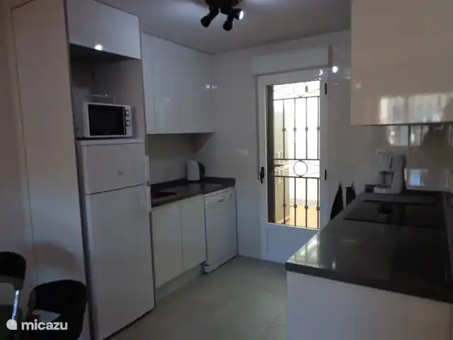 Location de Vacances Espagne, Costa Blanca, Orihuela Costa, appartement - Casa Bosque Cuisine moderne avec induction, four, lave-vaisselle et dans la buanderie derrière la porte une machine à laver et des cordes à linge.