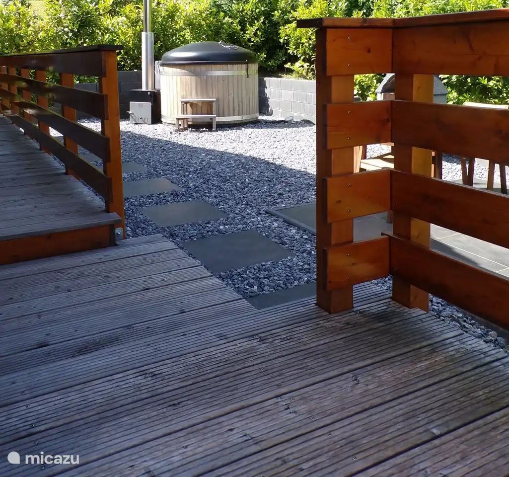 Von der Terrasse aus Blick auf den Gartenbereich mit Whirlpool und Essbereich