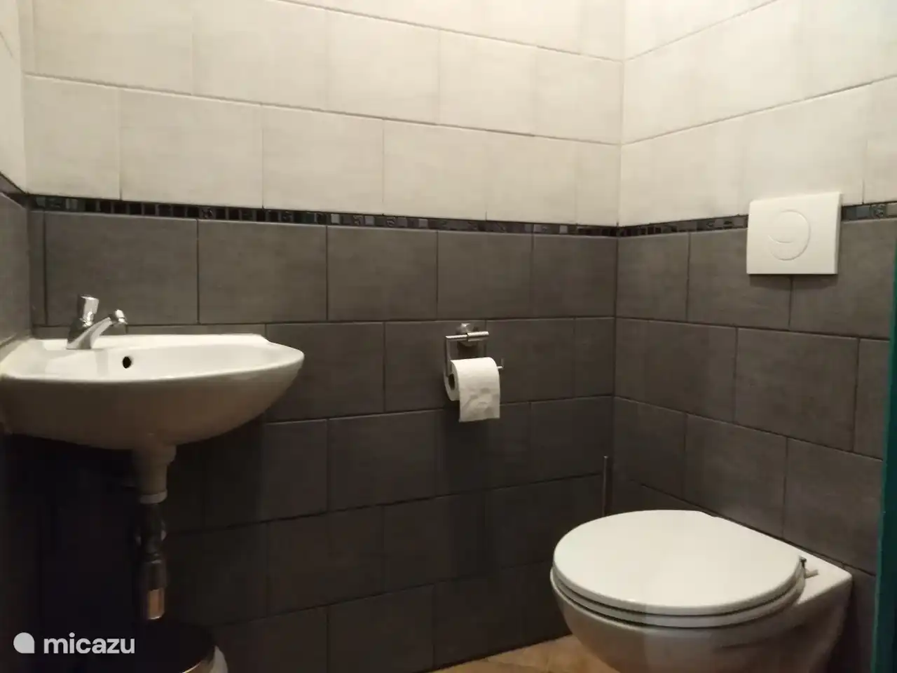 Durch den Flur in der Nähe der Dusche gelangt man in den separaten Toilettenraum