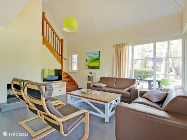 villa en Países Bajos, Güeldres, Beekbergen – La casa del estanque de Veluwe - ÚLTIMA HORA El luminoso salón está amueblado de forma atractiva, ideal para agradables veladas con la familia o los amigos junto a la chimenea crepitante. Puedes comprar madera para esto en el vestíbulo.