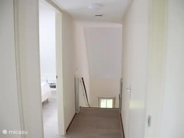 villa en Países Bajos, Güeldres, Beekbergen – La casa del estanque de Veluwe - ÚLTIMA HORA A través de las escaleras se llega al rellano desde la sala de estar, donde hay 2 dormitorios más amplios y un segundo baño y aseo. Para la seguridad de los niños, esto se puede cerrar con una puerta de escalera.