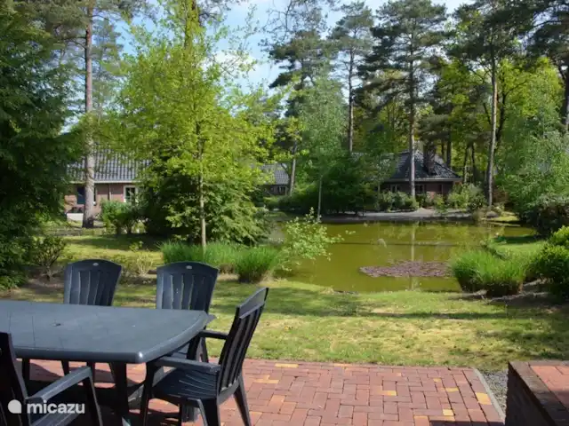 villa en Países Bajos, Güeldres, Beekbergen – La casa del estanque de Veluwe - ÚLTIMA HORA Disfrutando del desayuno o almuerzo al sol de la primavera, con una relajante vista al estanque. Debido a las plantas altas alrededor de la parcela, tiene suficiente privacidad.