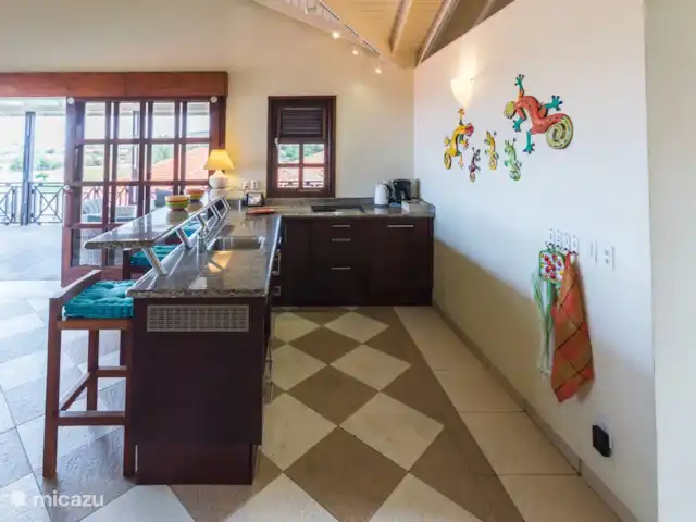 Vue sur l'océan 20 | Blue Bay | | Curaçao, Curaçao-Centre, Blue Bay - villa La cuisine ouverte avec bar est entièrement équipée, une cuisinière vitrocéramique 4 feux, lave-vaisselle, couverts, vaisselle et verres