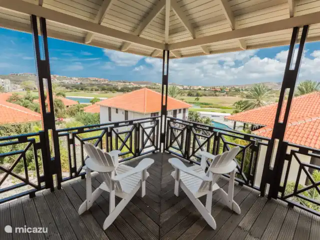 Vue sur l'océan 20 | Blue Bay | | Curaçao, Curaçao-Centre, Blue Bay - villa Le coin sud-ouest de la véranda surplombe les toits en pente, la piscine et la belle nature du terrain de golf. L'endroit idéal pour profiter ensemble de cette vue coloniale.