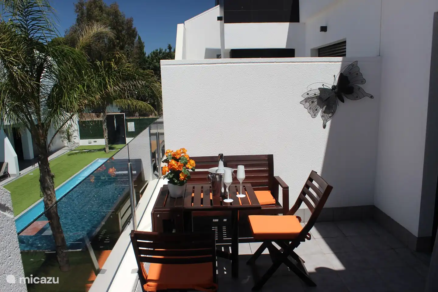 Balkon mit Blick auf den Garten mit Pool