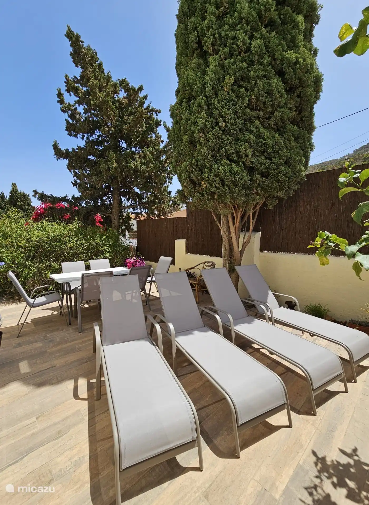 Terrasse avec table à manger et chaises longues